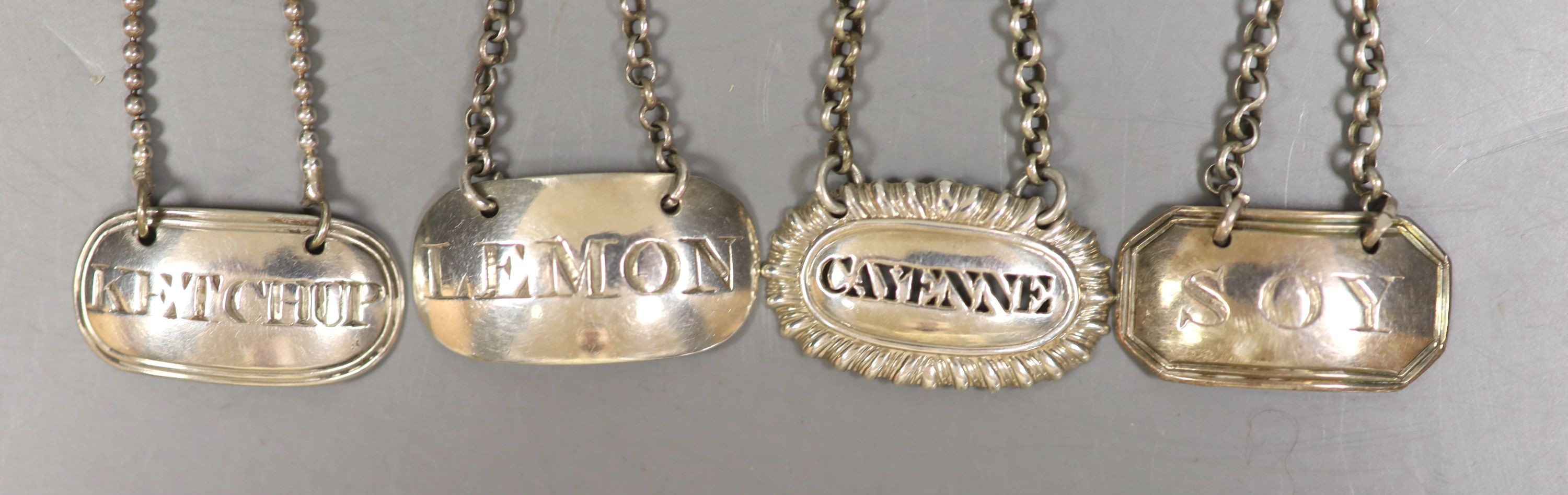 Four Georgian silver condiment labels, Soy, London, 1797, 27mm, Lemon, London, 1804, Ketchup, London, 1810 and Cayenne by Reily & Storer.